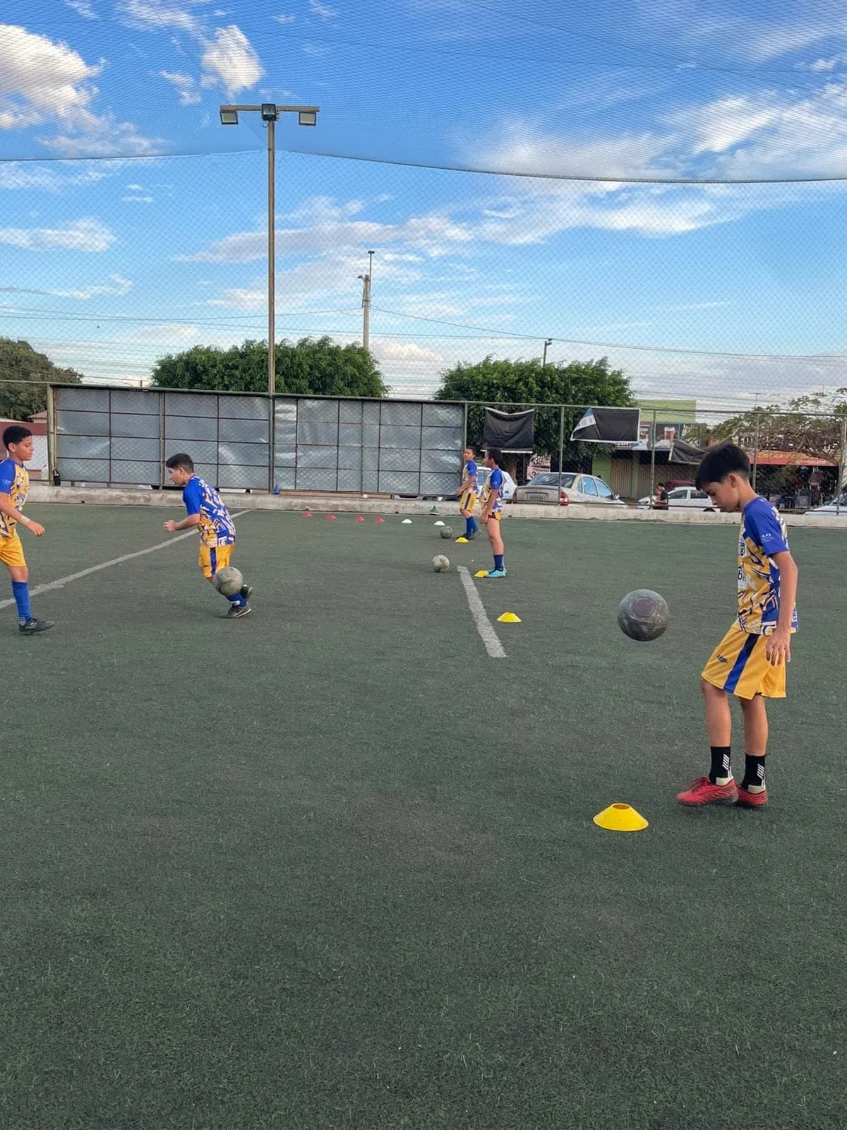 Treino de condução de bola no campo society
