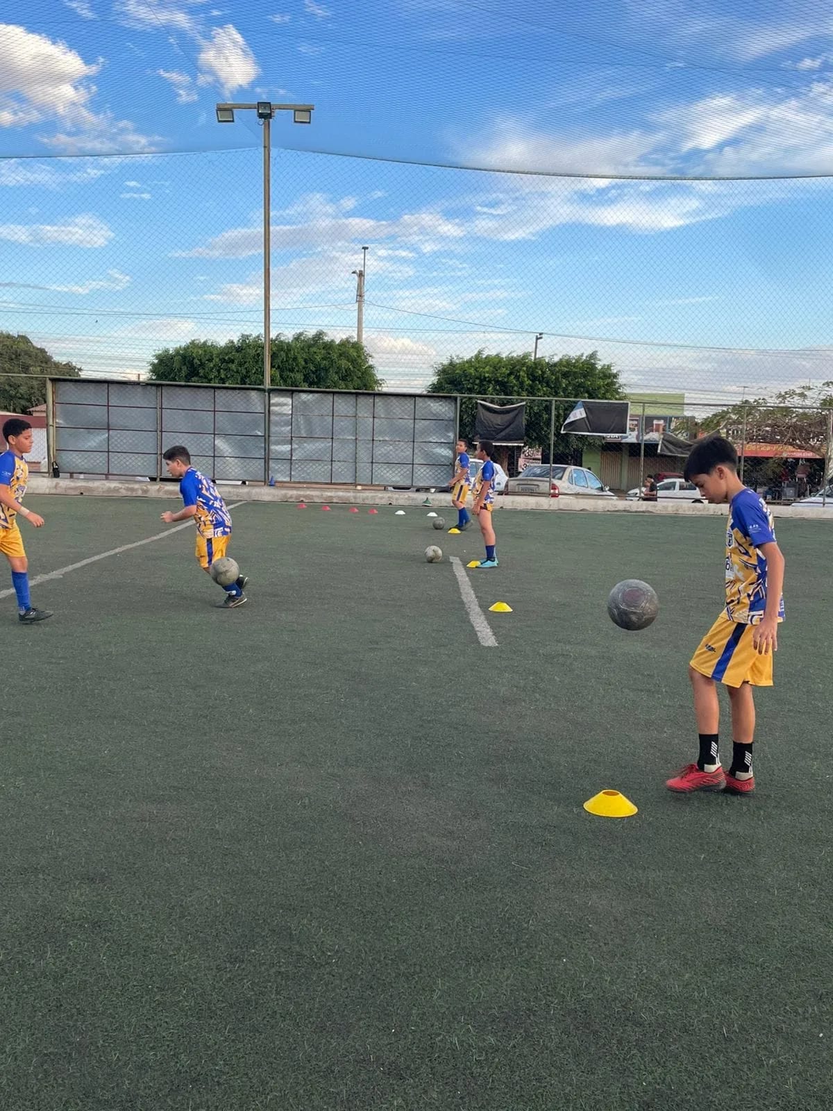 Treino de condução de bola no campo society