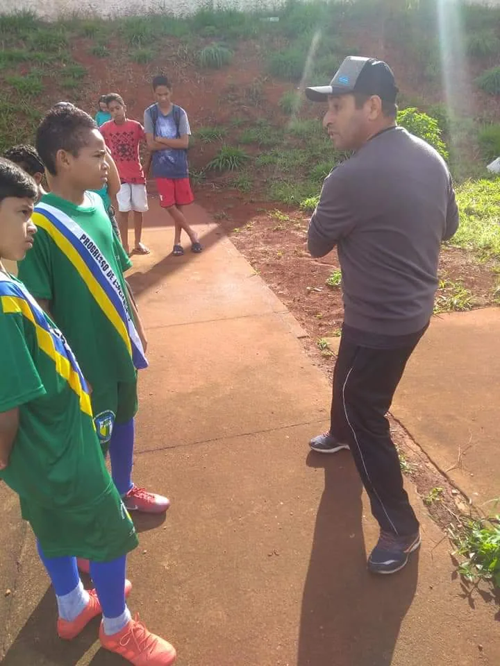 Treinador orientando um aluno na beira do campo