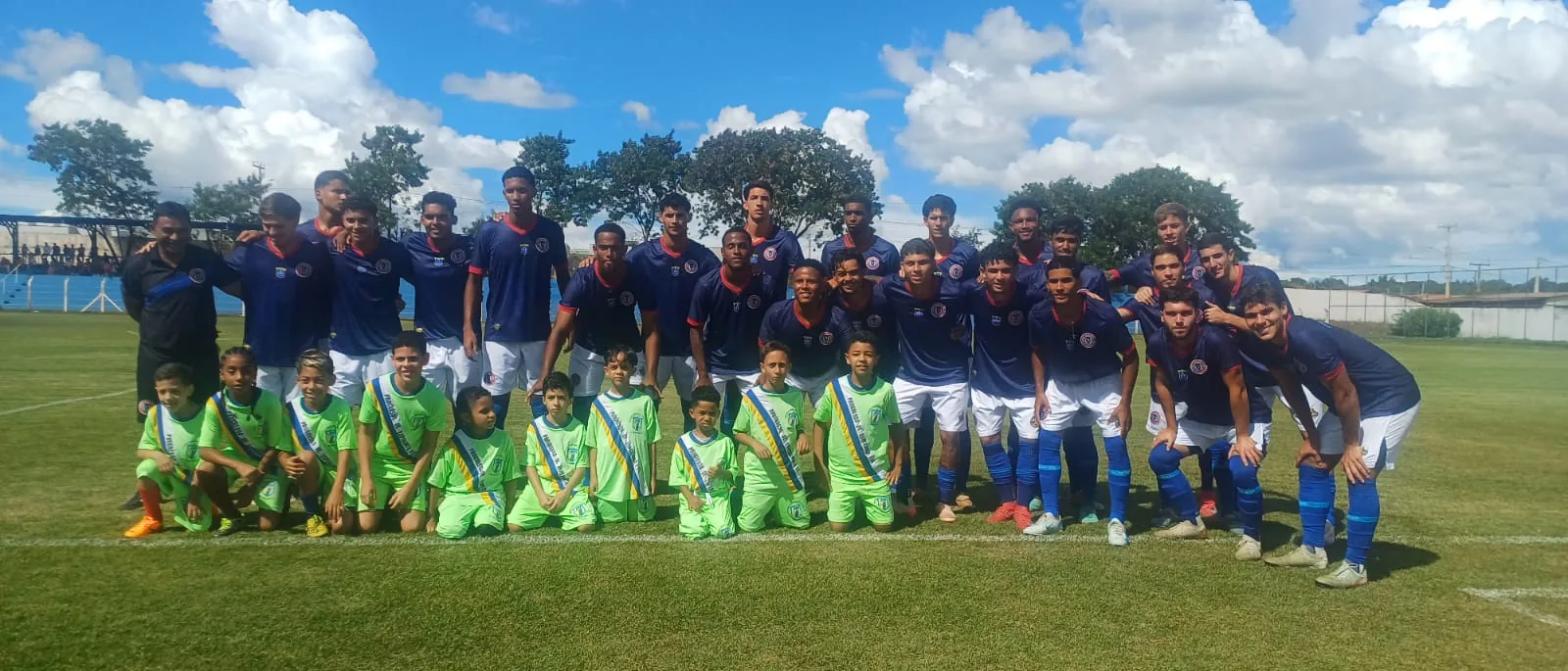 Duas equipes posando juntas no gramado após a partida