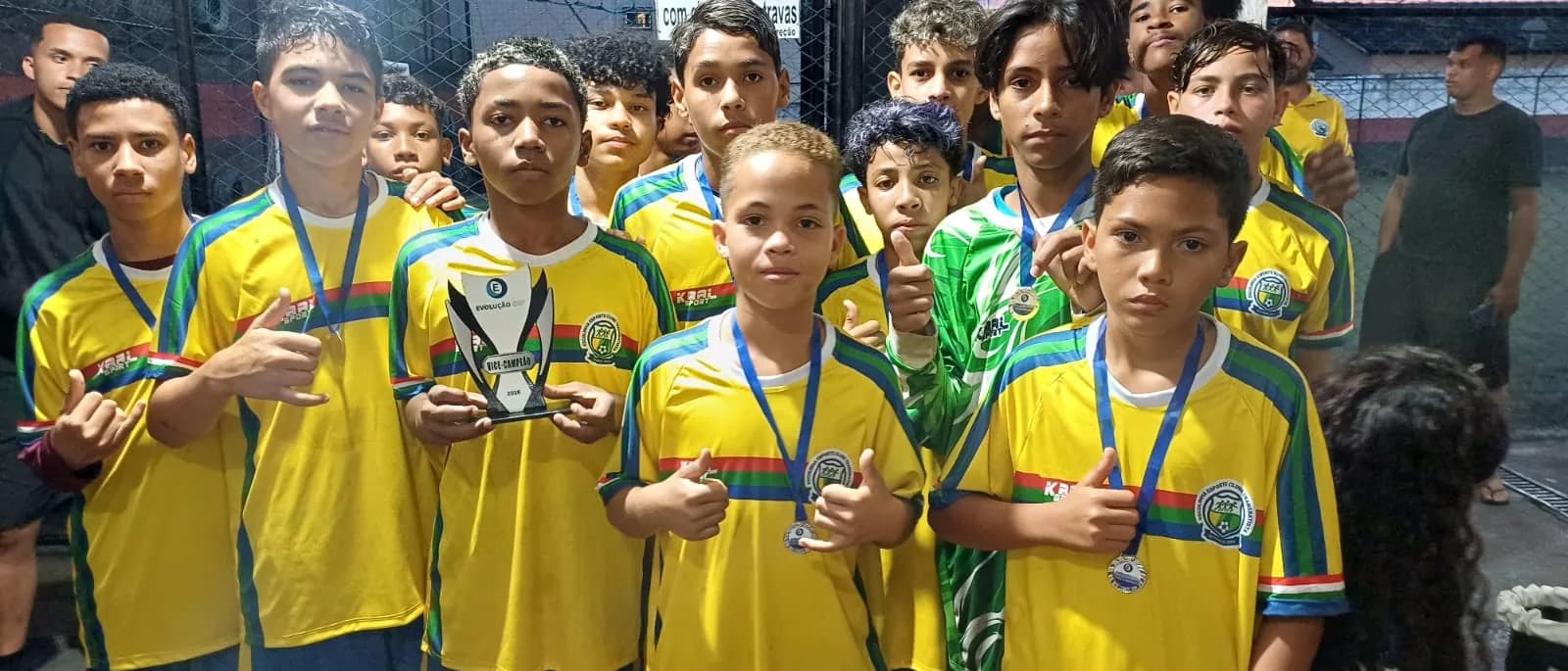 Atletas exibindo medalhas e troféu após a competição