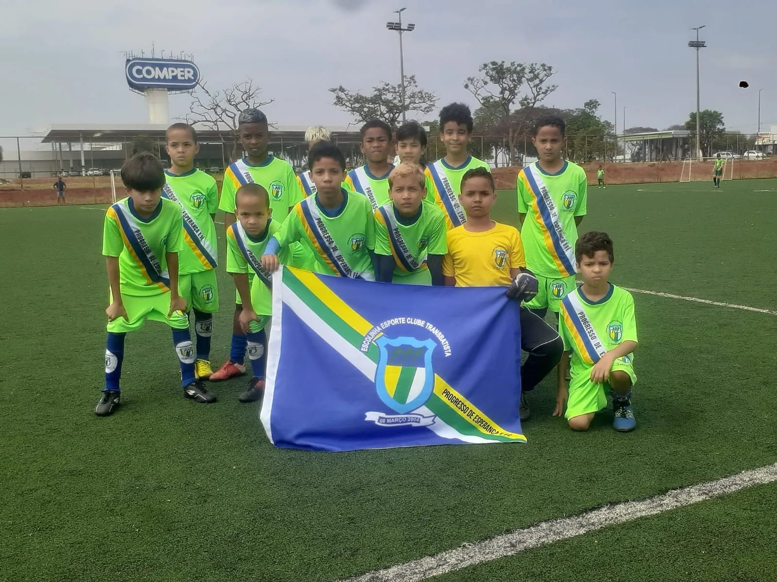 Equipe de verde-limão com a bandeira do clube